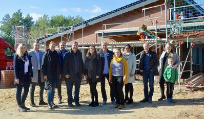 Bürgermeister Marc Breitenfeld (5. v. li.) freut sich mit Architekt Torsten Stelling (2. v. re.) und weiteren Gästen über die neue Kita, die im Frühjahr 2023 fertig sein soll.