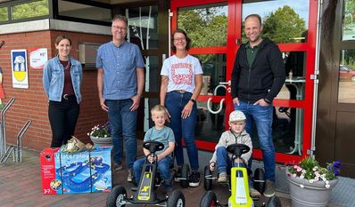 Kai Bahrs (2. v. l.) freut sich mit den Kindern über die Fahrzeuge und die Wasserbahn.