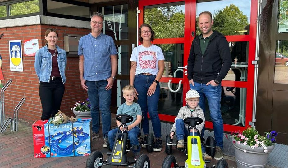 Kai Bahrs (2. v. l.) freut sich mit den Kindern über die Fahrzeuge und die Wasserbahn.