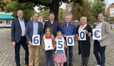 Freuen sich über die Gewinnübergabe: Die Sieger:innen sowie die Volksbankmitarbeitenden Jan Mackenberg (links) und Pia-Sophie Meyer (rechts).