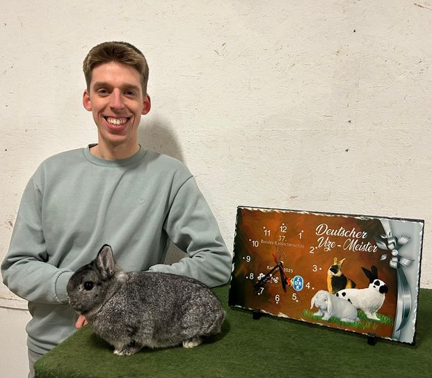 Jonas Lilienthal mit einem Farbenzwerg chinchillafarbig und seinem Preis als Deutscher Vizemeister.