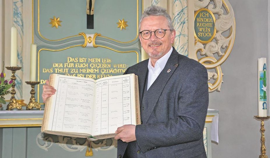 Landrat Bernd Lütjen (Osterholz) zeigt das Kirchenbuch der St. Cosmae und Damiani-Kirche in Hambergen, in dem die Hochzeit von Helmut und „Loki“ Schmidt am 1. Juli 1942 festgehalten wurde.