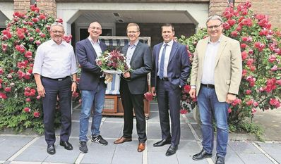 Tim Jesgarzewski (2.v.l.) verabschiedet sich mit einem Blumenstrauß von Stefan Kalt (Mitte).