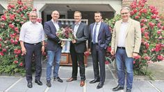 Tim Jesgarzewski (2.v.l.) verabschiedet sich mit einem Blumenstrauß von Stefan Kalt (Mitte).